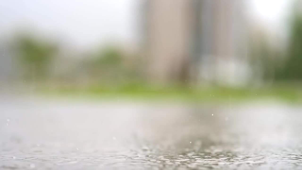 一个城市暴雨的大气视频。大雨和溅起的水坑从低点拍摄。视频素材