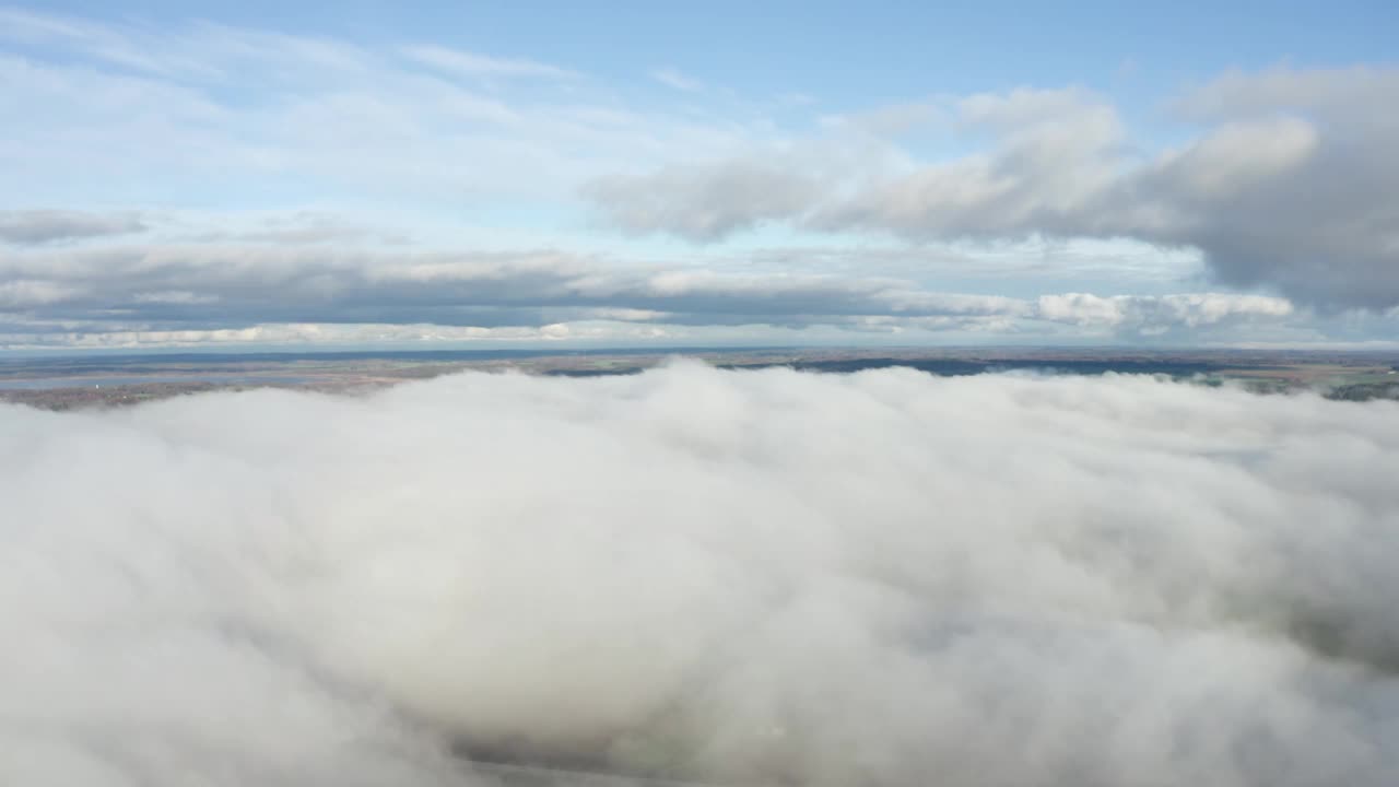 缓慢平静的空中白色蓬松的云床之间的天空视图在陆地的地平线视频素材