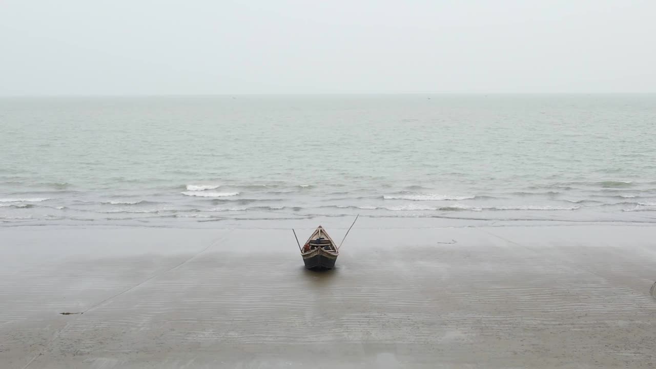 孤立在荒芜的海滩上。小的空渔船和桨。空中视频素材