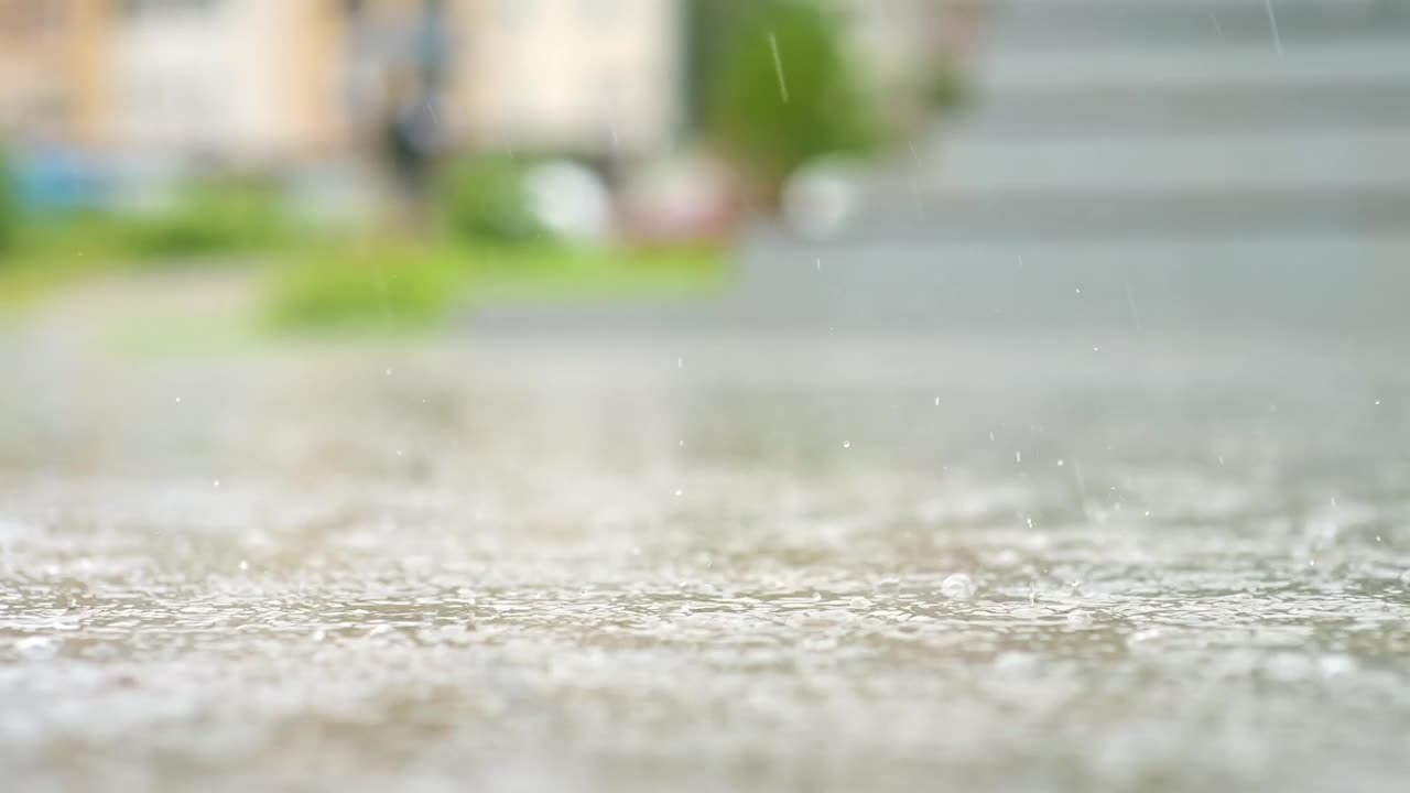 一个城市暴雨的大气视频。大雨和溅起的水坑从低点拍摄。视频素材