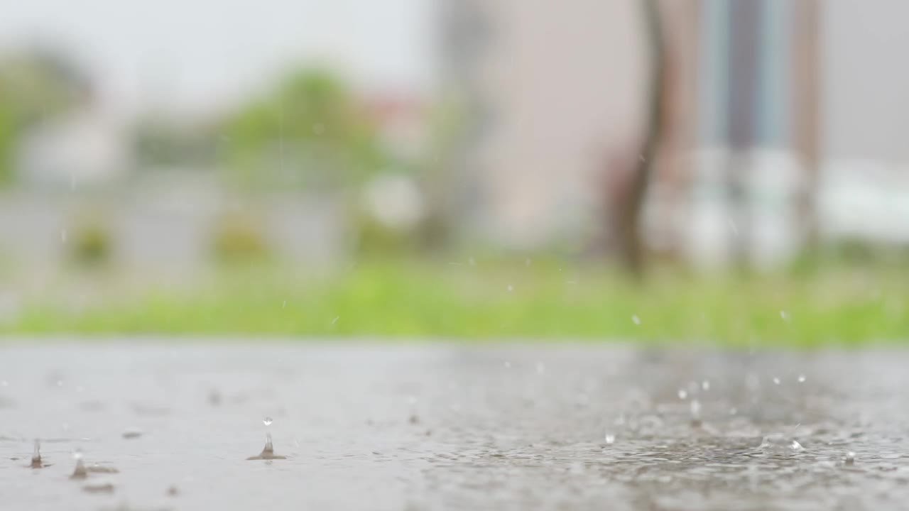 一个城市暴雨的大气视频。大雨和溅起的水坑从低点拍摄。视频素材