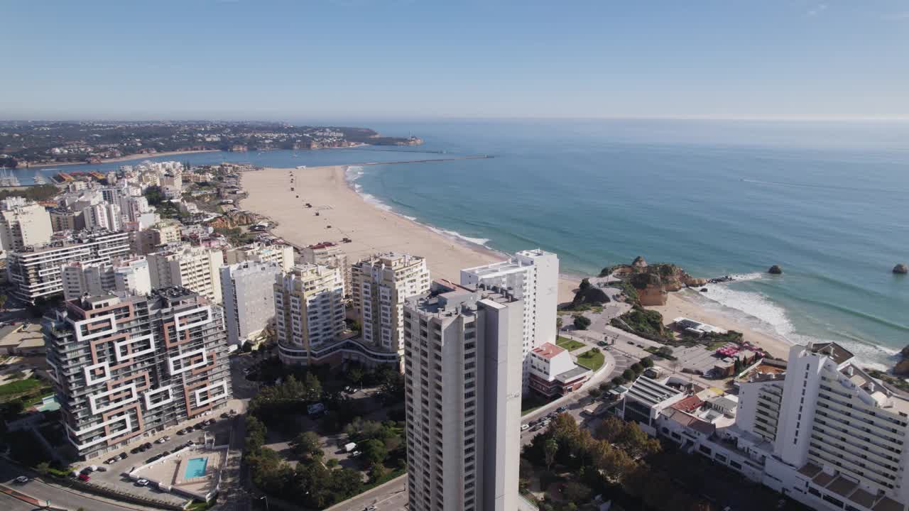 无人机建立海滩普拉亚达罗查在葡萄牙Portimao，背后的摩天大楼视频素材