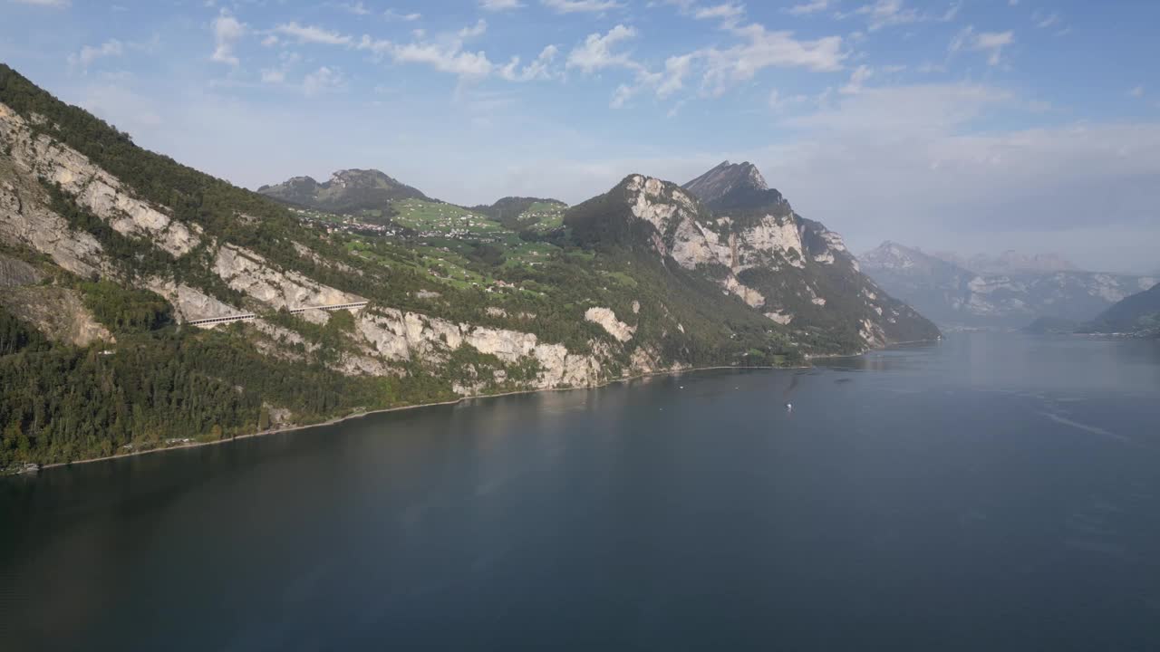 缓慢变焦拍摄的一个大的水体在辅助山峰在白天与晴朗的天空和云视频素材