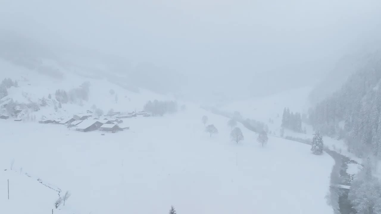 寒冷的高山冬季景观在降雪鸟瞰图视频下载