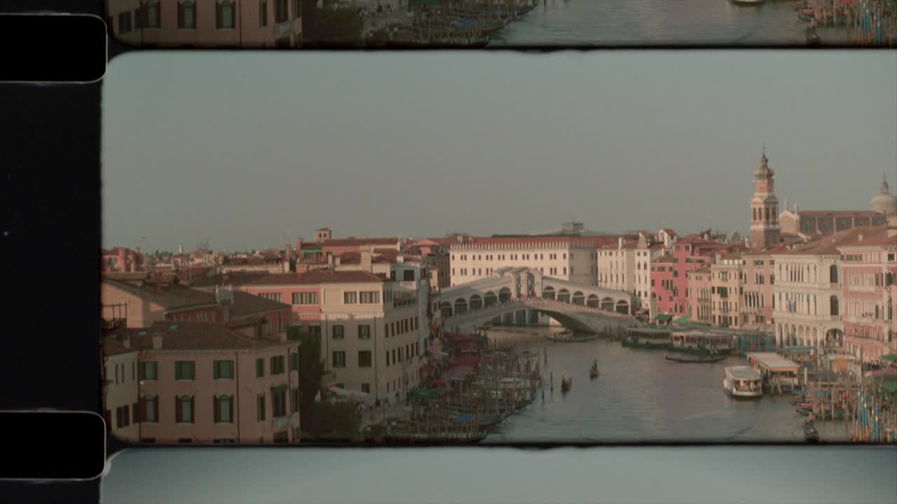 阳光下的意大利威尼斯大运河上的里亚托桥鸟瞰图。4 k视频下载