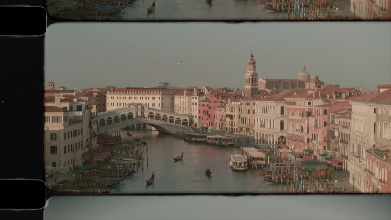 阳光下的意大利威尼斯大运河上的里亚托桥鸟瞰图。4 k视频下载