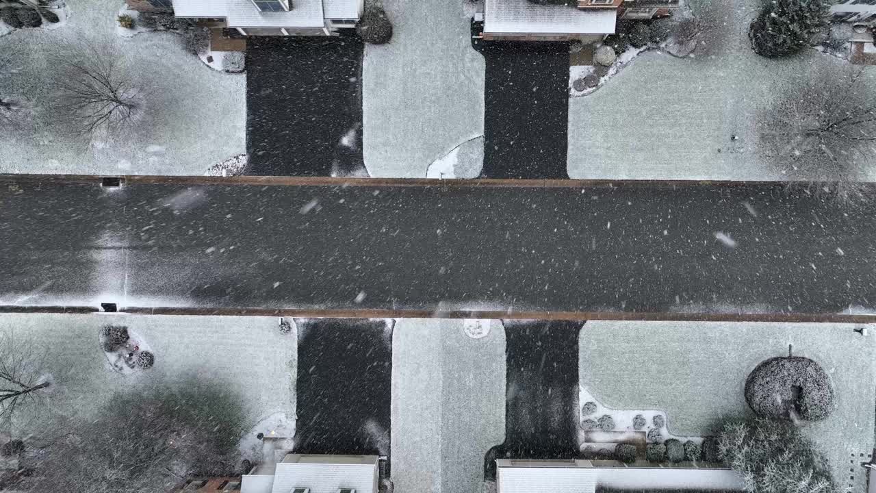 从空中俯瞰，白雪覆盖的街道和光秃秃的树木。暴风雪期间的美国居民区。视频素材