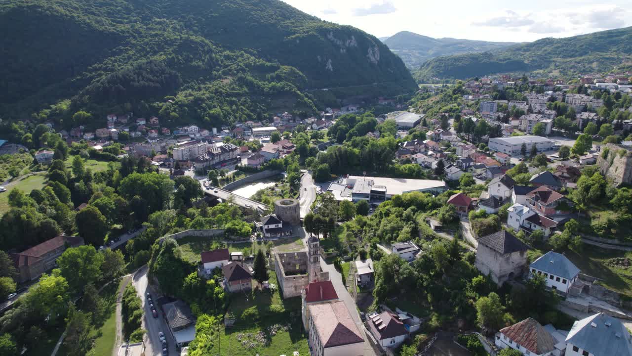 在波斯尼亚和黑塞哥维那，森林山脉环绕的风景如画的城市亚伊采上空的空中撤退视频素材