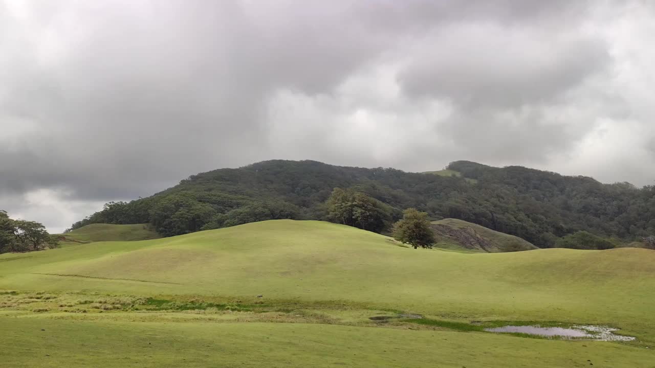 绿色的小山，背景是多云的天空视频素材