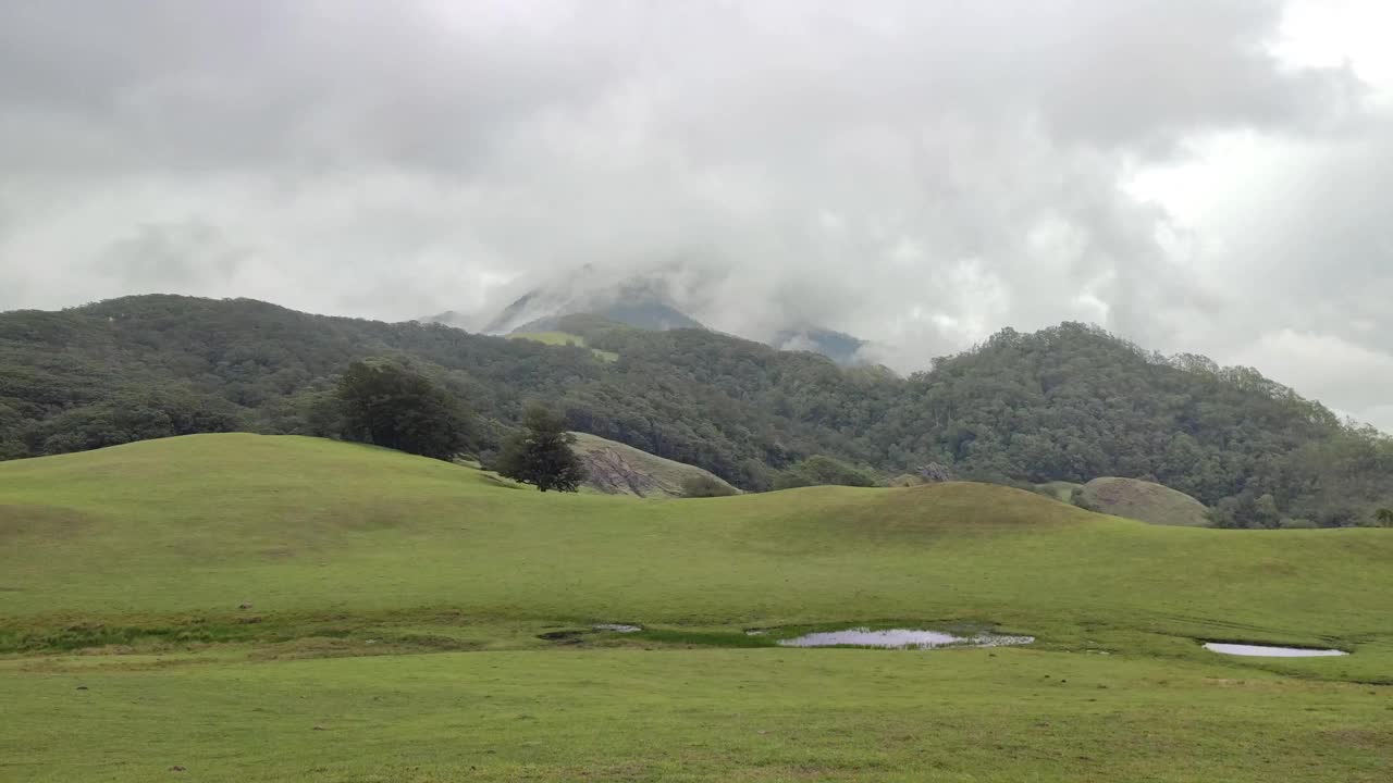 绿色的小山，背景是多云的天空视频素材