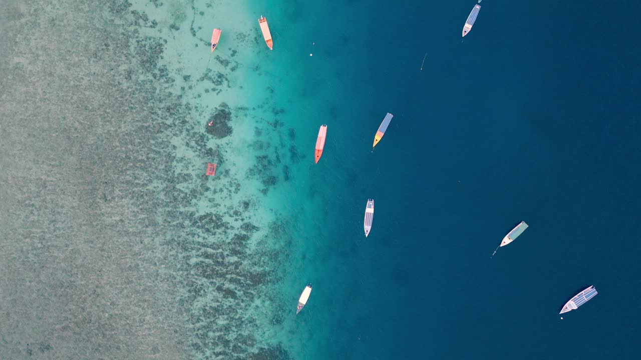 从空中俯瞰漂浮在蓝色水面上的船，夏日海岸的海景。海滨自然中游船人的休闲活动海洋泻湖大西洋海岸的游泳天气视频素材