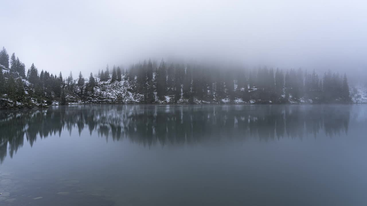 在瑞士阿尔卑斯山的一个神秘的湖泊里，雾蒙蒙的时间流逝。视频素材