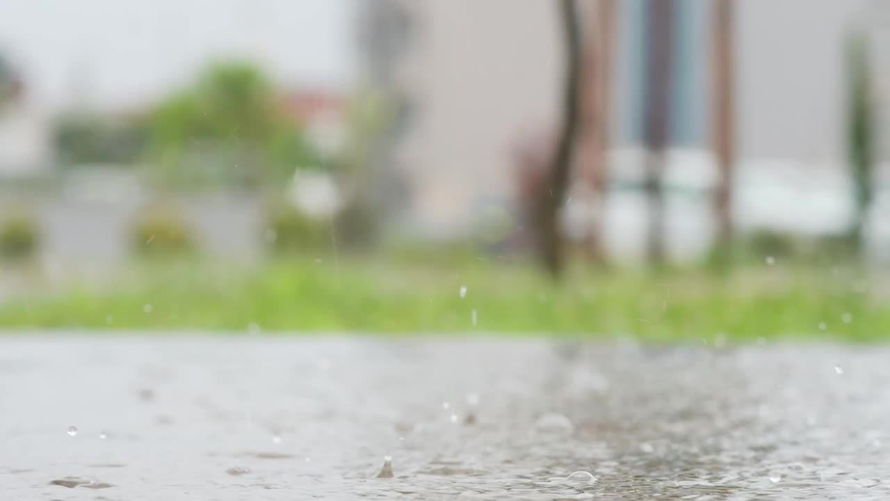 一个城市暴雨的大气视频。大雨和溅起的水坑从低点拍摄。视频素材