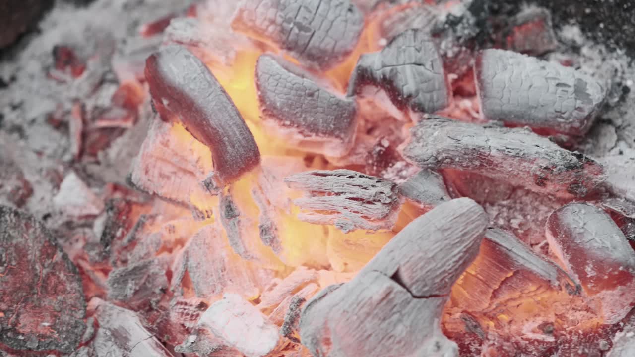 一些非常热的木炭在烤架上燃烧的慢动作和火焰的特写视频素材