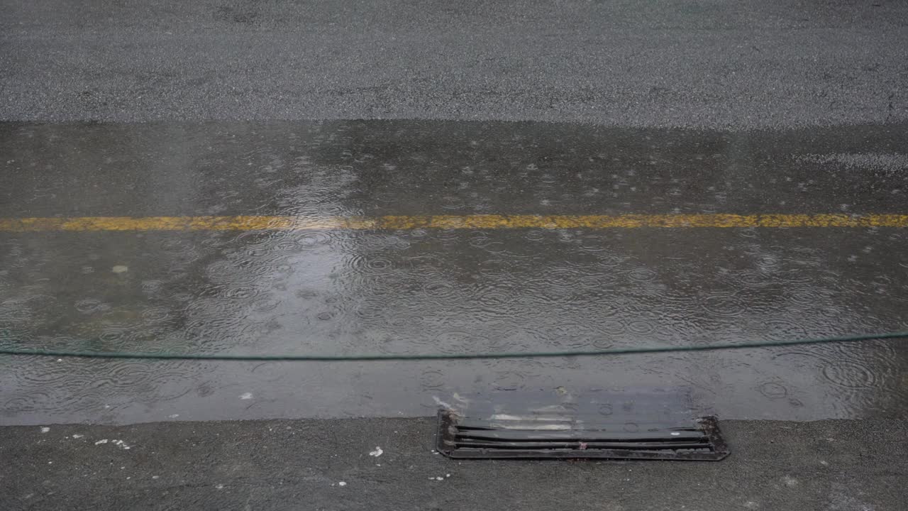 雨水淹没了城市的街道，汽车驶过视频素材