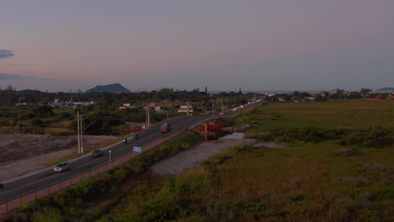 黄昏时宁静的高速公路鸟瞰图，周围是绿色植物和远山视频素材