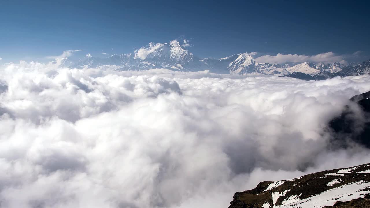 从khopra山脊上看到的云在道拉吉里上空翻滚的全景视频素材