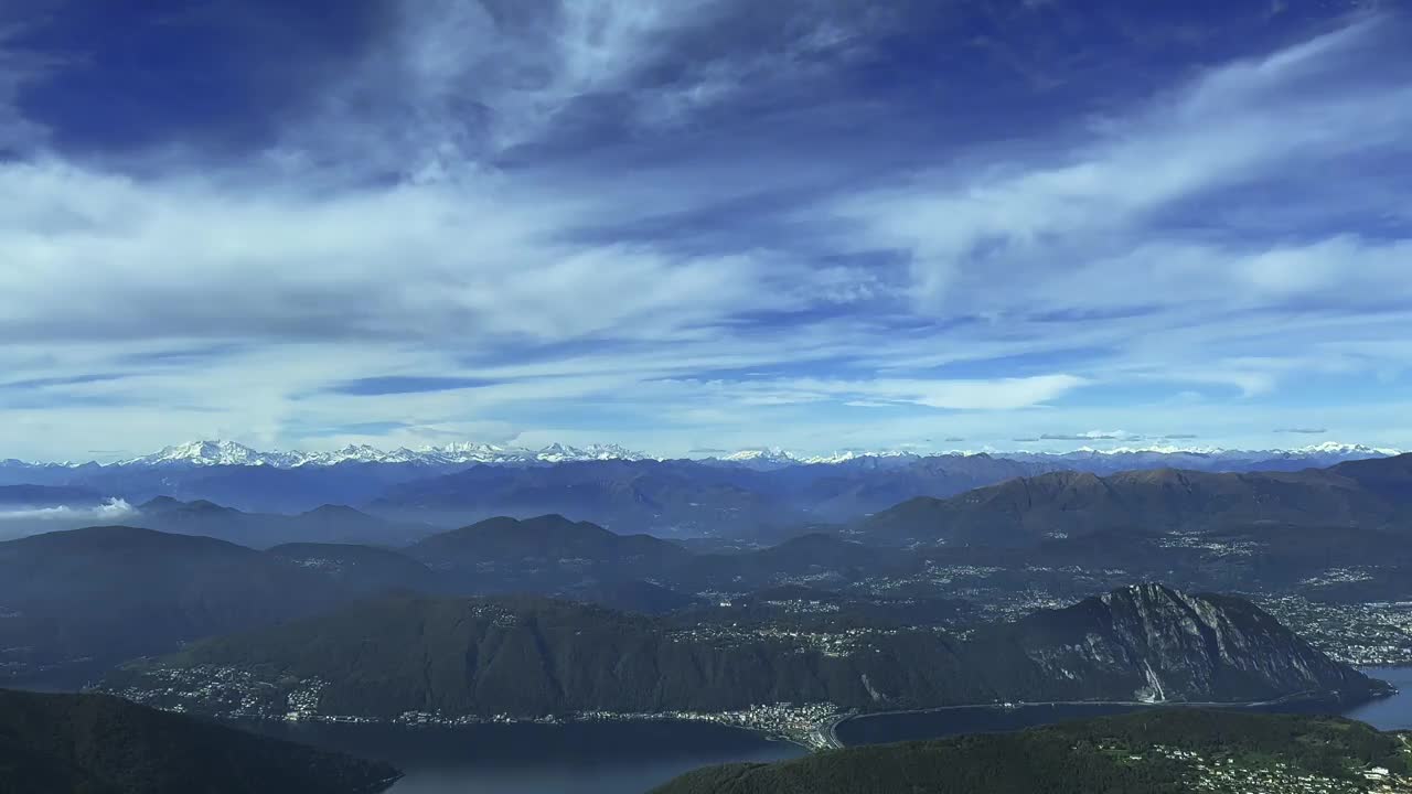 鸟瞰图在美丽的卢加诺湖和城市和山景与白雪覆盖的罗莎山和马特洪峰在一个阳光明媚的日子视频素材