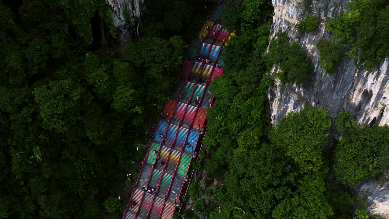 游客爬上彩色陡峭的台阶，前往马来西亚雪兰莪州贡巴克的拔都洞穴。-航拍视频素材