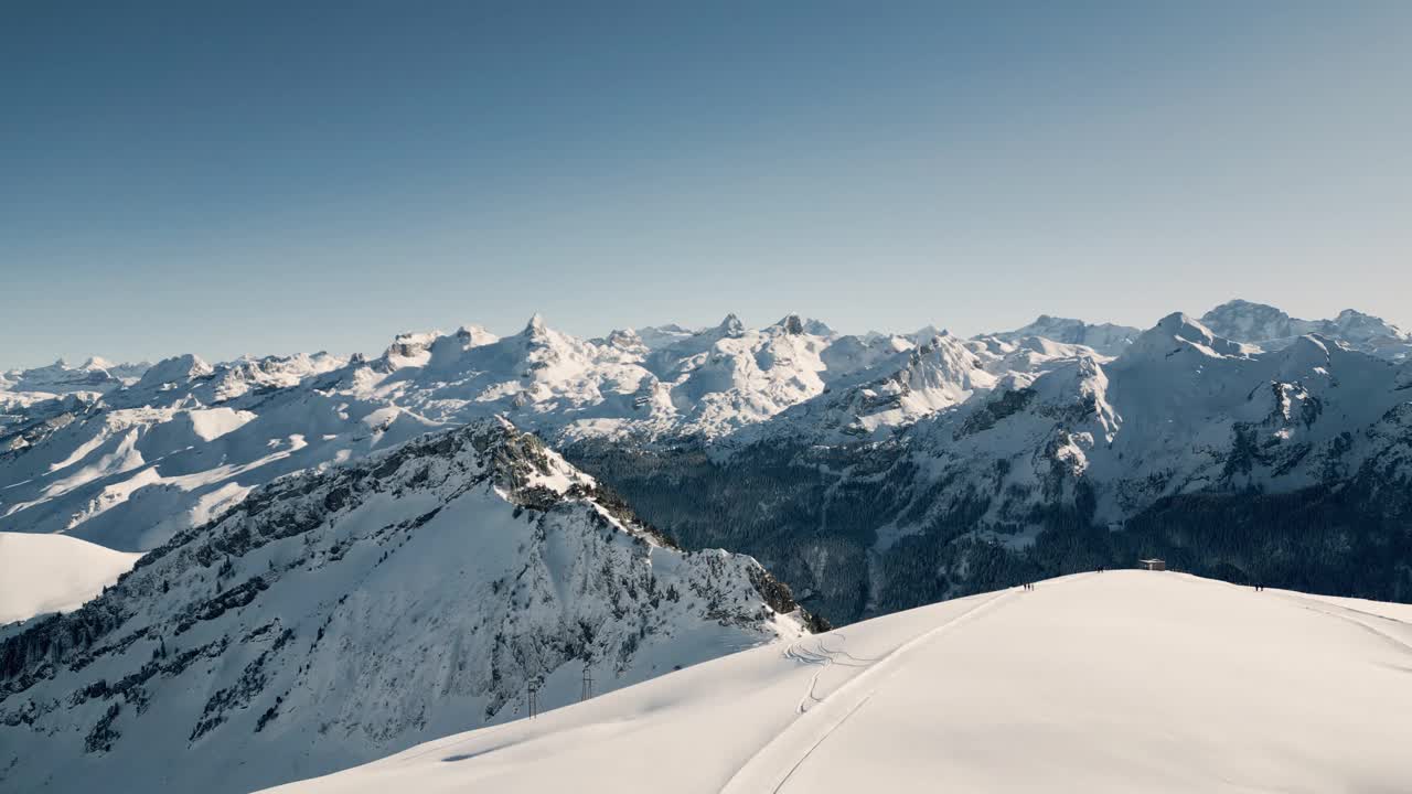 冬季美景鸟瞰斯托斯的Fronalpstock，滑雪者在斜坡上。瑞士视频下载