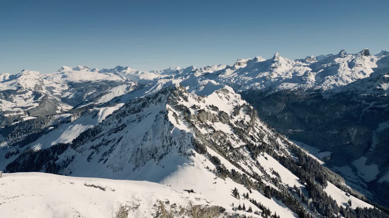 冬季美景鸟瞰斯托斯的Fronalpstock，滑雪者在斜坡上。瑞士视频下载