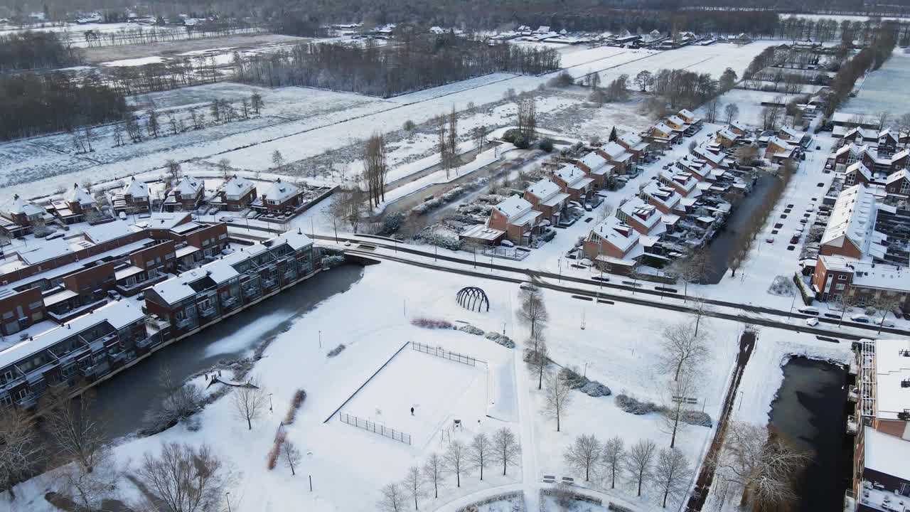 美丽的鸟瞰图，在一个阳光明媚的冬日，一个乡村郊区被雪覆盖视频素材