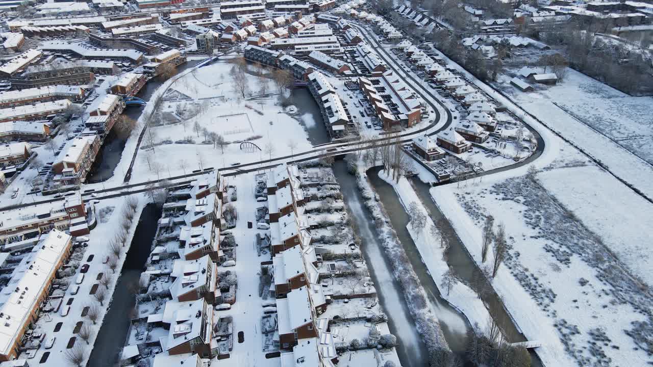 一个美丽的中产阶级社区被雪覆盖的航拍图。一个白色的公园位于郊区的中心视频素材