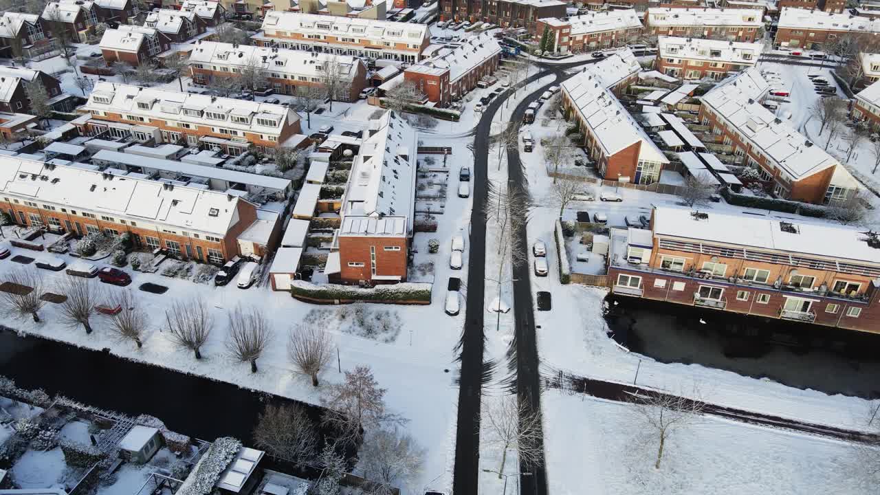 在积雪覆盖的小镇上，汽车行驶在干净的道路上视频素材