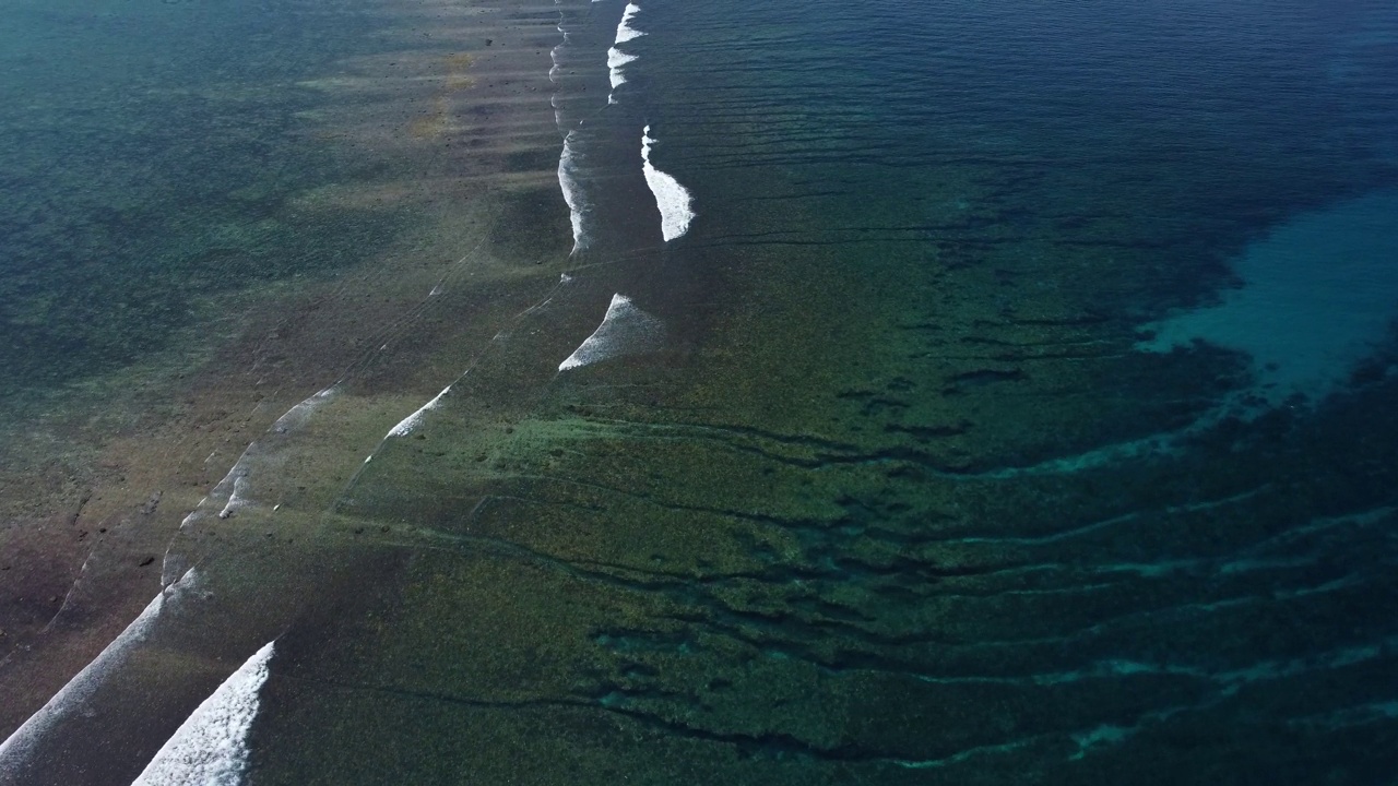 在清澈的海水中，波浪在浅滩中达到顶峰和破裂，鸟瞰图视频素材