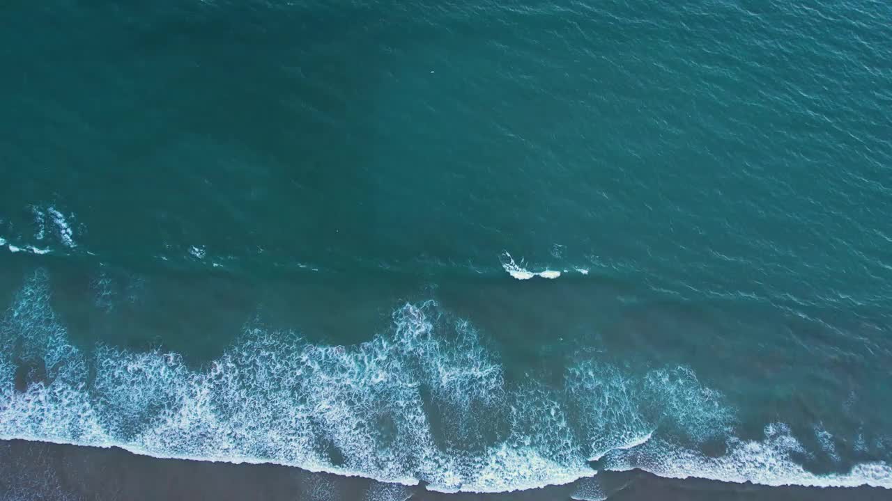 航拍的泡沫海浪冲到沙滩上视频素材