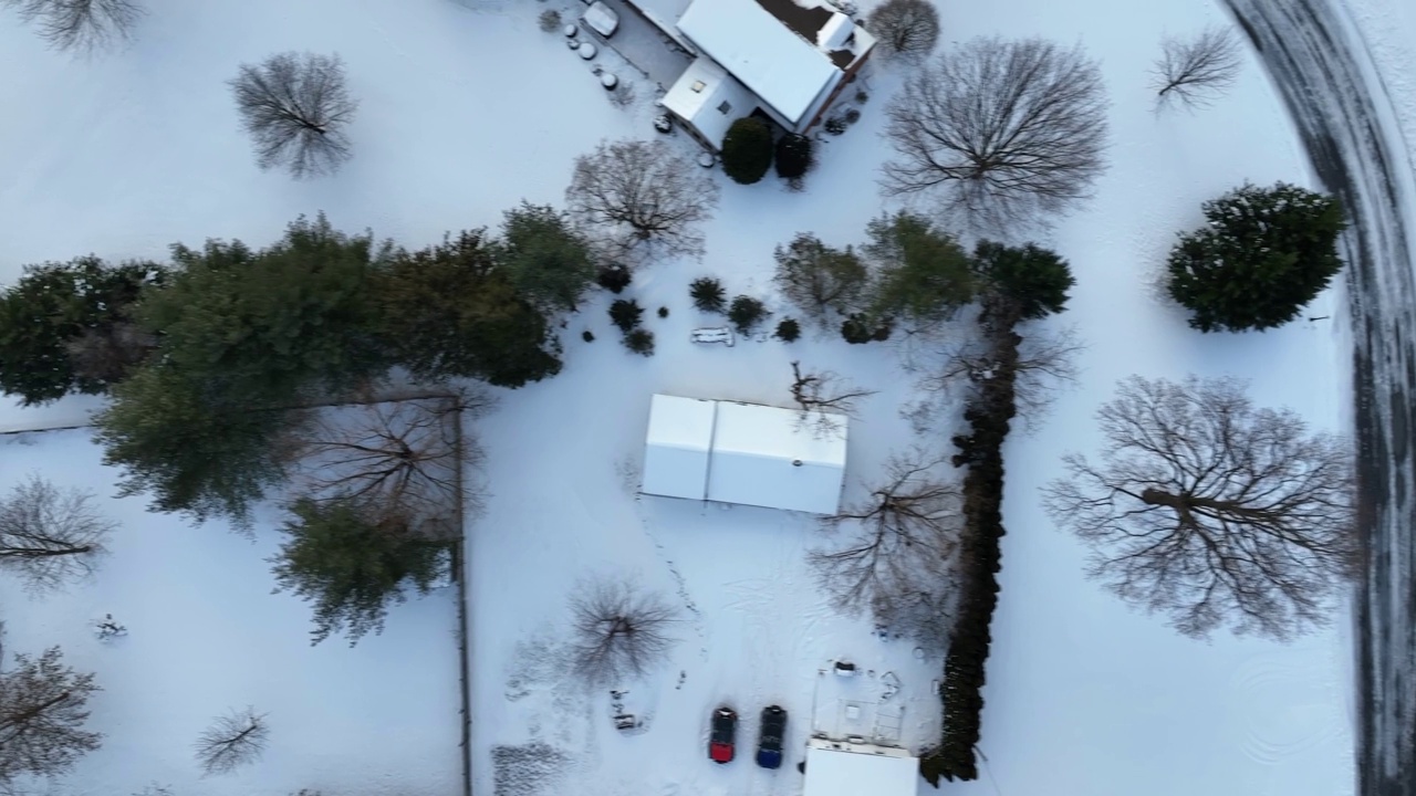 屋顶上覆盖着白色的冬雪。航拍卡车上的房屋，车库，车道。鸟瞰图。视频素材