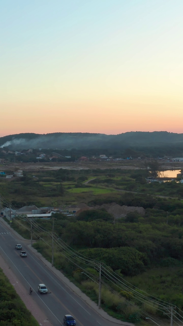 黄昏时宁静的高速公路鸟瞰图，周围是绿色植物和远山视频素材