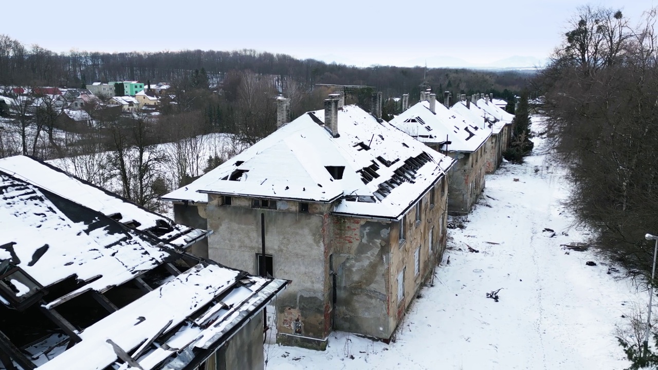 鸟瞰图:一排废弃的、破旧的建筑在雪景中，营造出一种怪异和荒凉的气氛视频素材