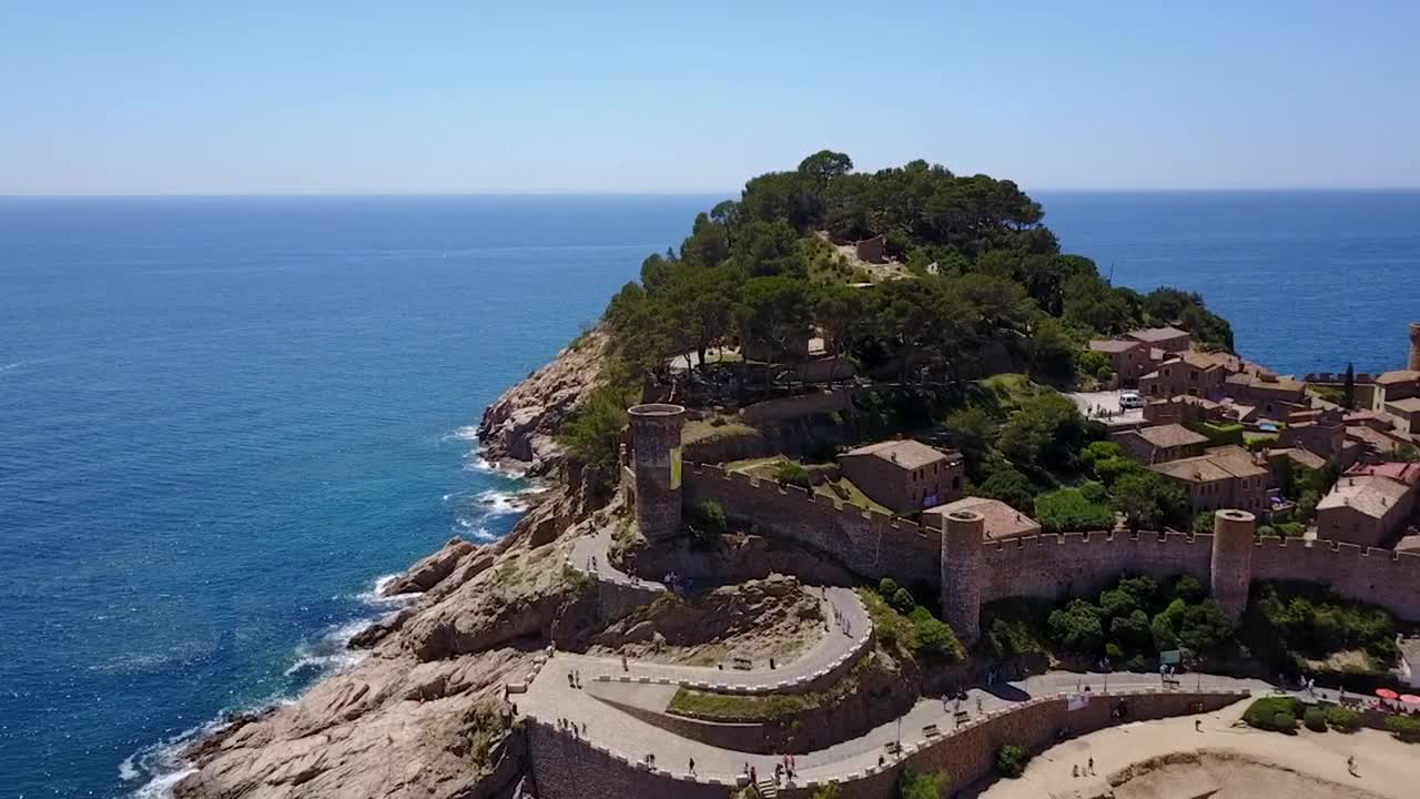 在靠近山丘的地方有一座城堡，坐落在地中海的岩石海岸线上视频素材