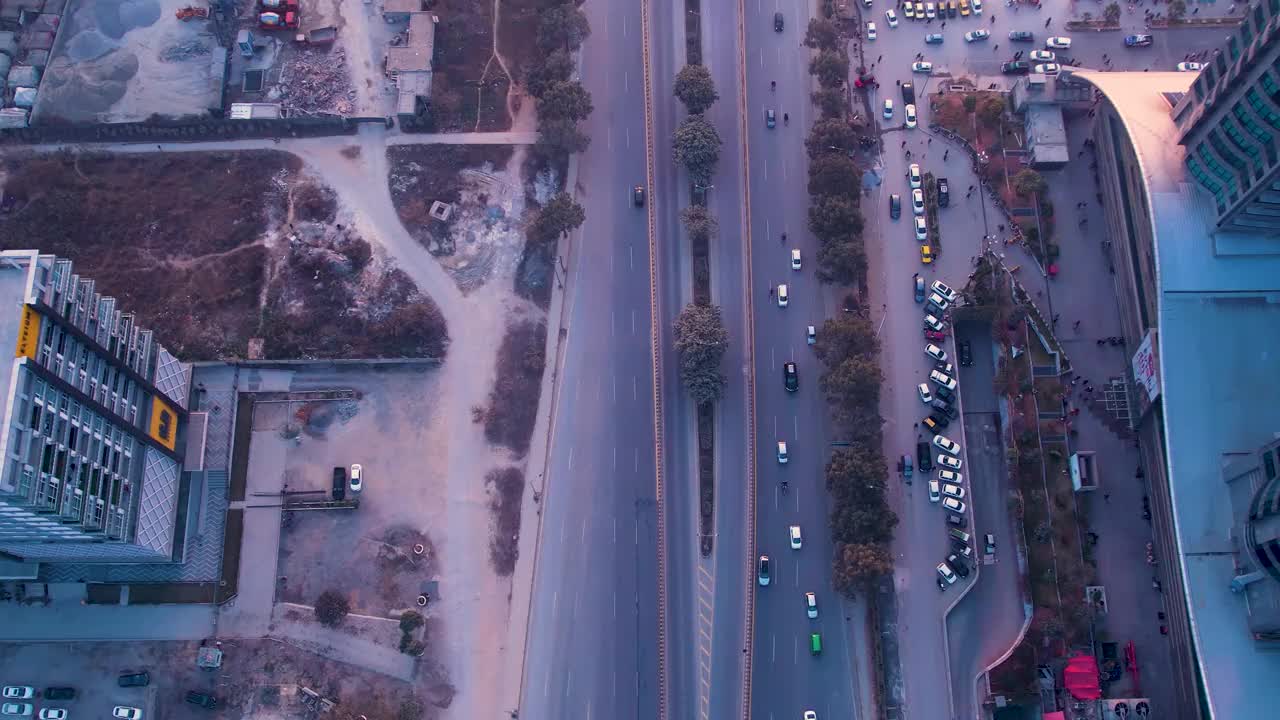 这是巴基斯坦伊斯兰堡一条繁忙道路的俯视图，旁边是一个停车场，旁边有一个地铁站视频素材