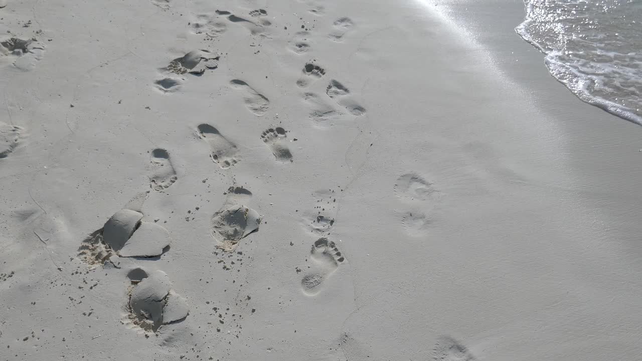 沙滩上的脚印，沙滩上的浪花视频素材