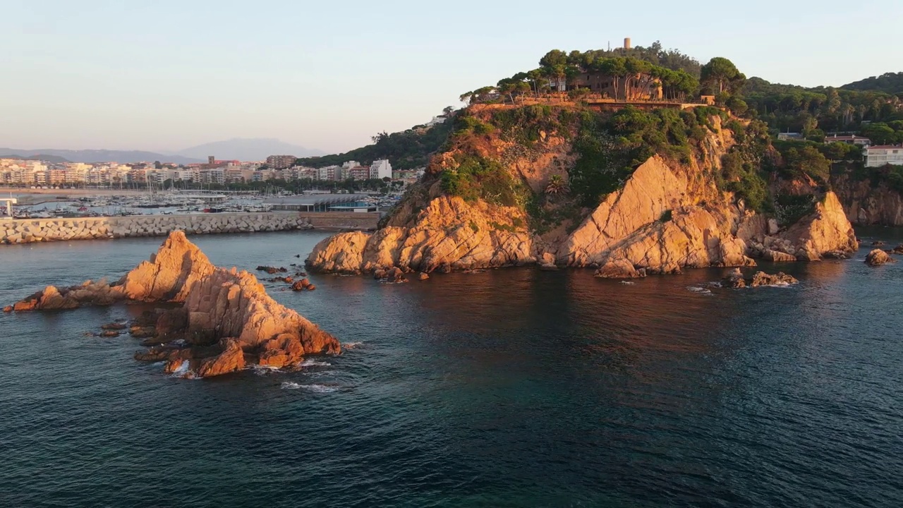 夕阳下的海岸悬崖和海岸小镇，鸟瞰图视频素材