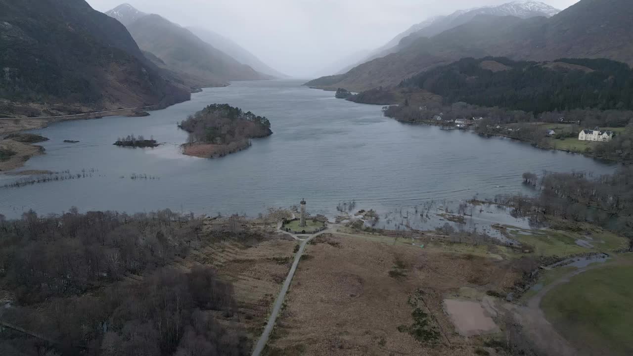 格伦芬南高架桥在苏格兰与郁郁葱葱的景观，宁静的湖泊，和喜怒无常的天空，鸟瞰图视频素材