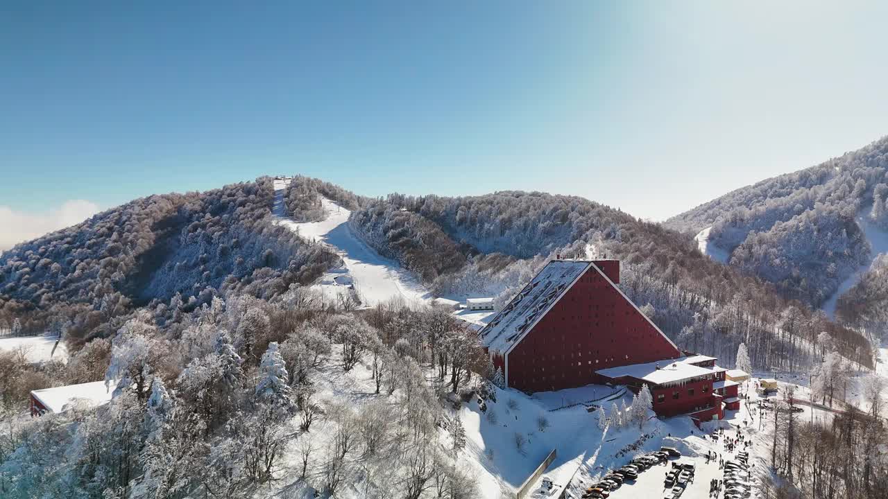 鸟瞰滑雪胜地的山坡在一个明亮的阳光明媚的冬日在山上。视频素材