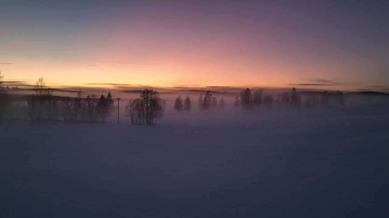 瑞典松兹瓦尔附近，黎明时分白雪覆盖的风景，雾气和树木的剪影视频素材