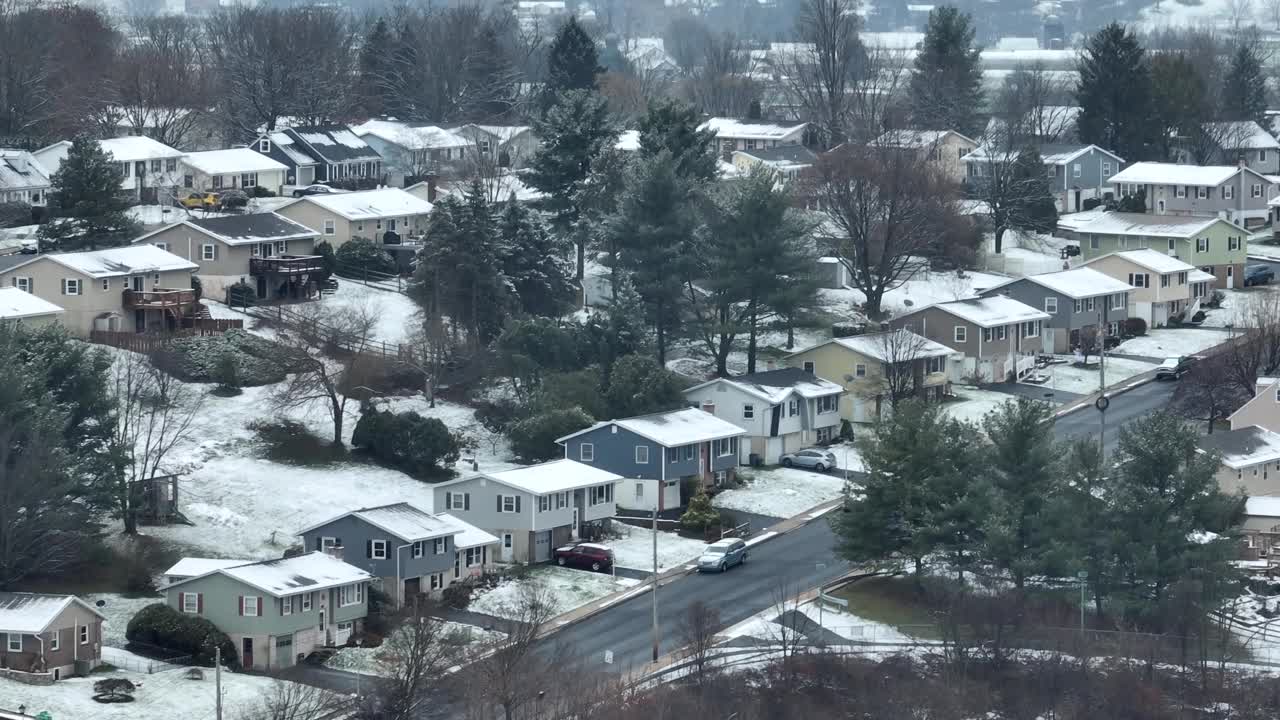 冬雪时山顶上的美国住宅区。背景是冰冻的农村农场。航拍变焦上升镜头。视频素材