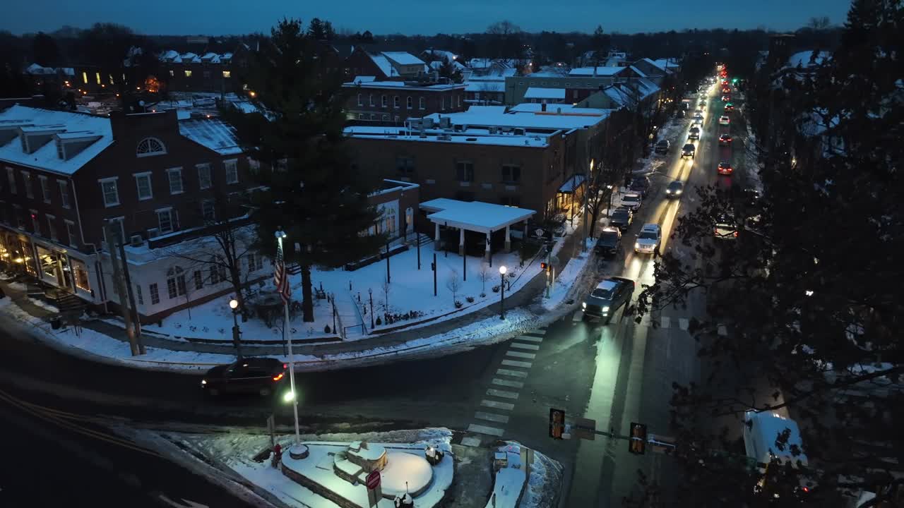 建立无人机拍摄的交通在黄昏美国城市的主要道路。冬天，屋顶被雪覆盖。空中自上而下的上升镜头。视频素材