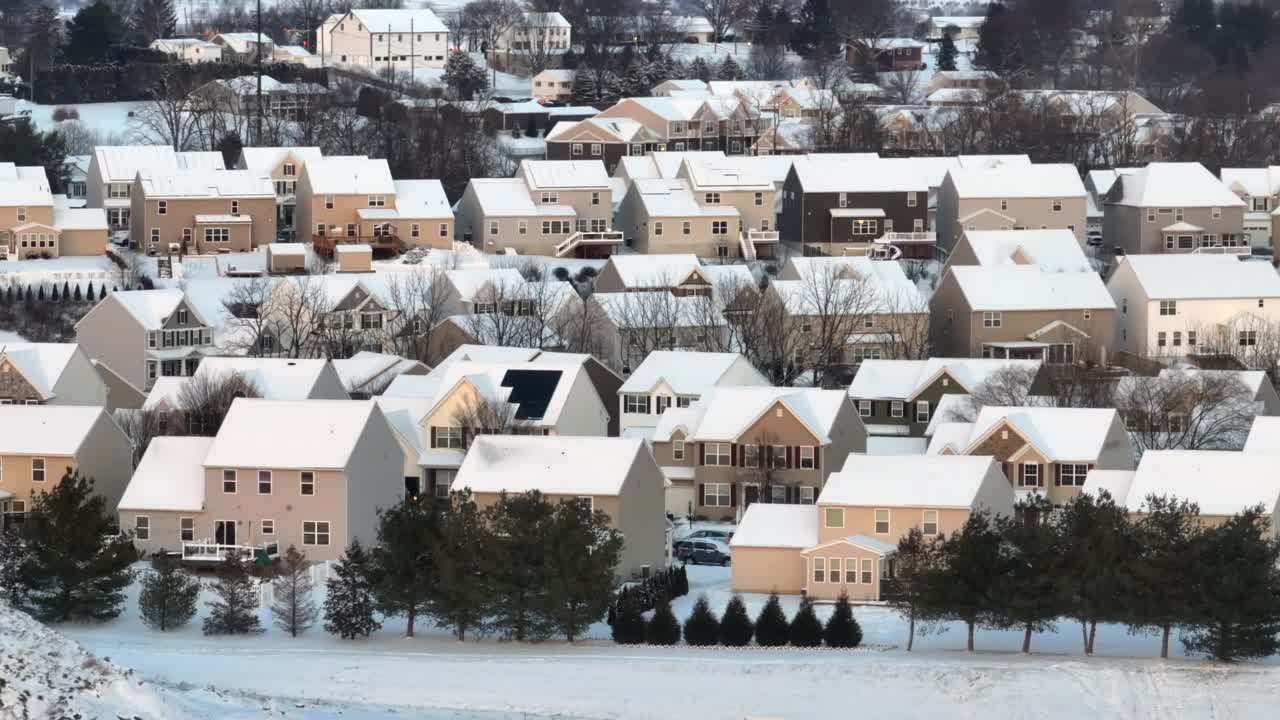 密集的郊区社区，米色的房子在日落时被雪覆盖。美国多雪地区的空中视差。视频素材