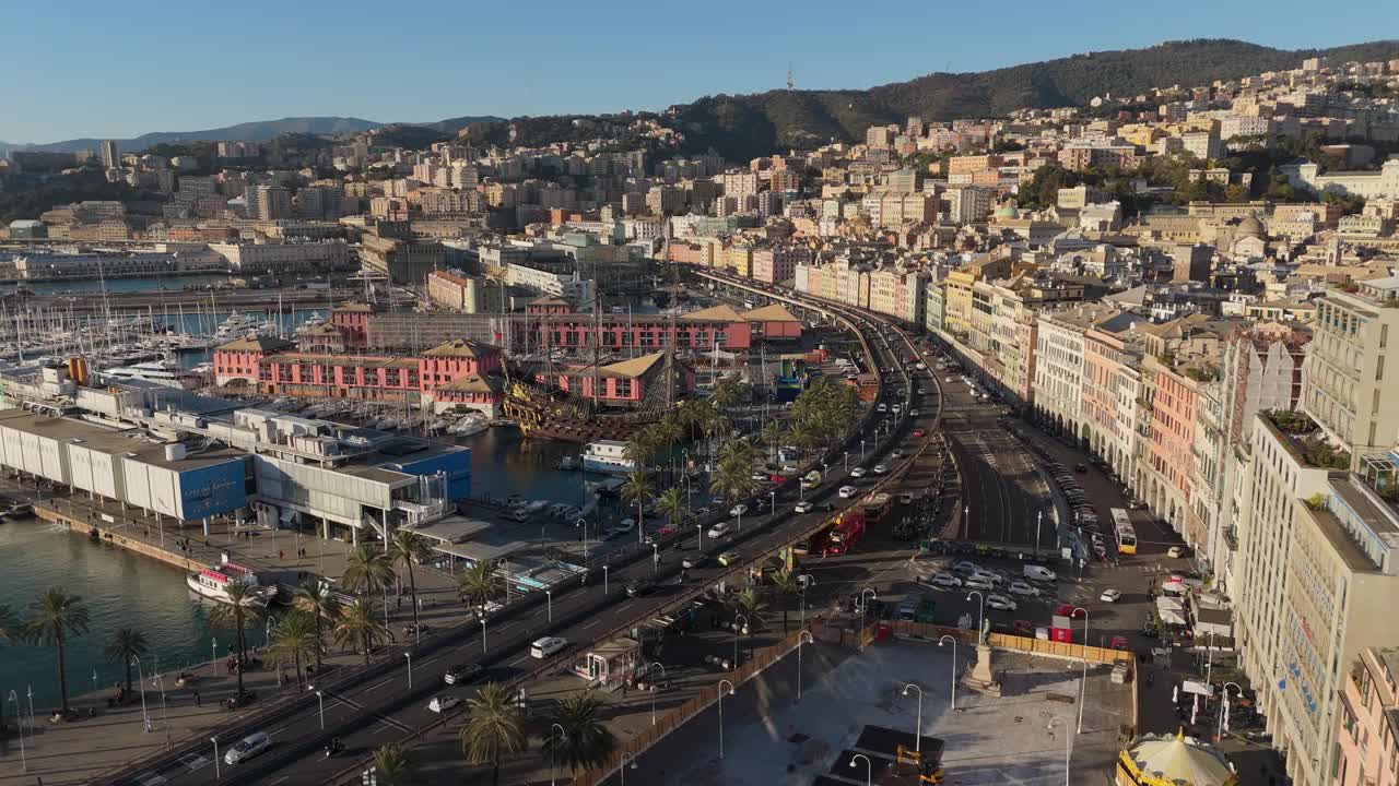 热那亚熙熙攘攘的港口和历史建筑上的夕阳，棕榈树和交通视频素材