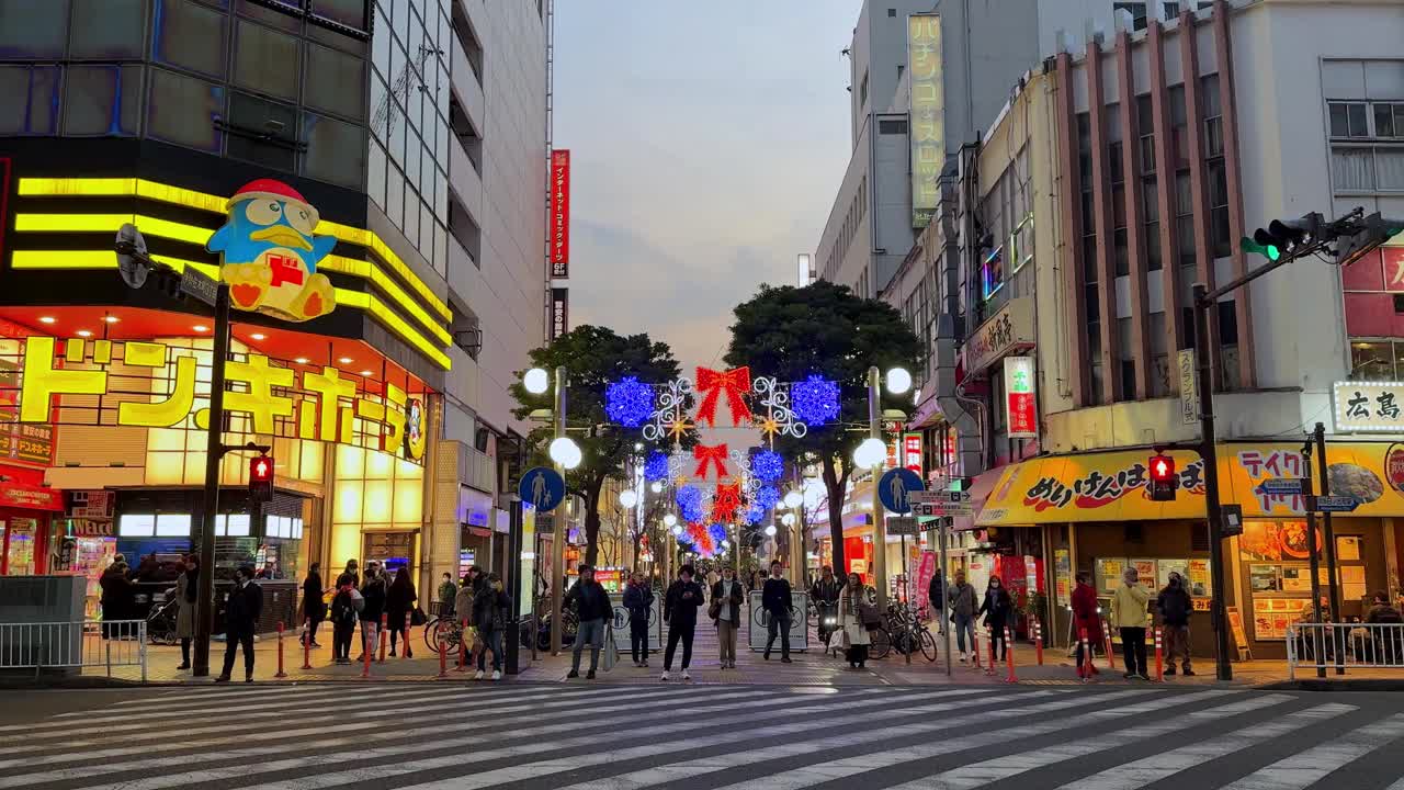 黄昏降临在充满活力的城市街道上，行人熙熙攘攘，霓虹灯随处可见视频素材