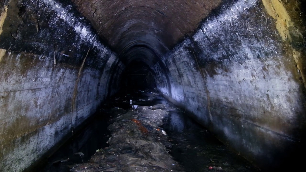 地下拱形城市下水道隧道与肮脏的污水视频下载