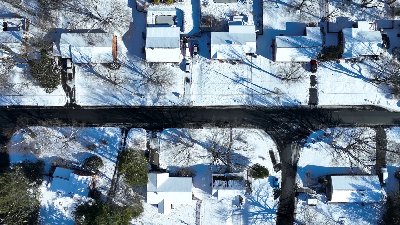 鸟瞰覆盖屋顶的雪。从上方俯瞰冬天的美国社区街道。视频素材