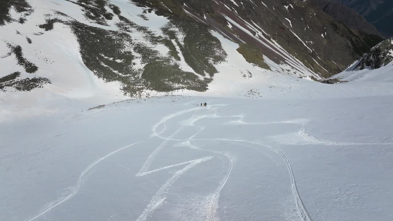 一群滑雪者站在山上的雪坡上。滑雪旅游自由骑行鸟瞰图视频素材