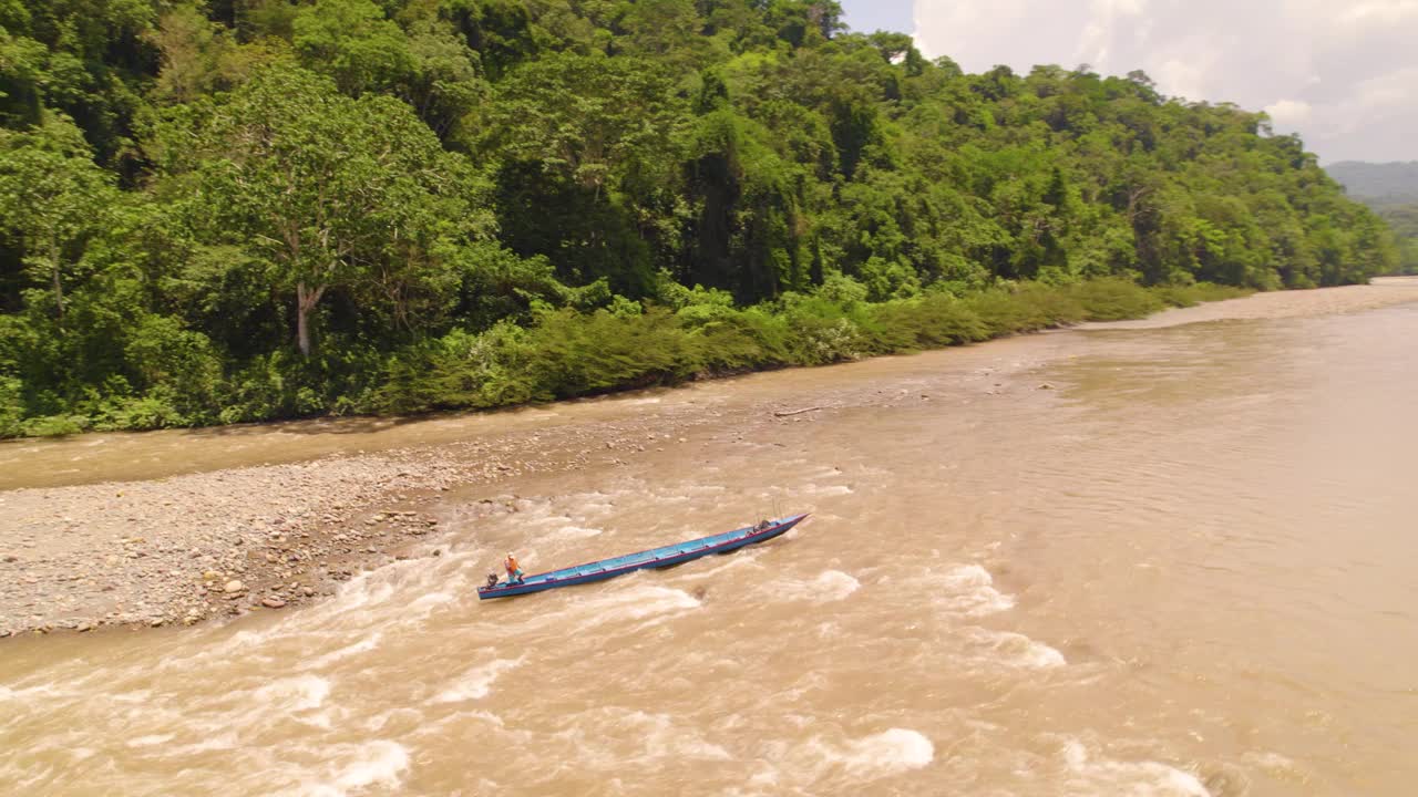 在奥克斯帕帕河浑浊的水域上，由当地人驾驶的长独木舟，周围是茂密的丛林视频素材