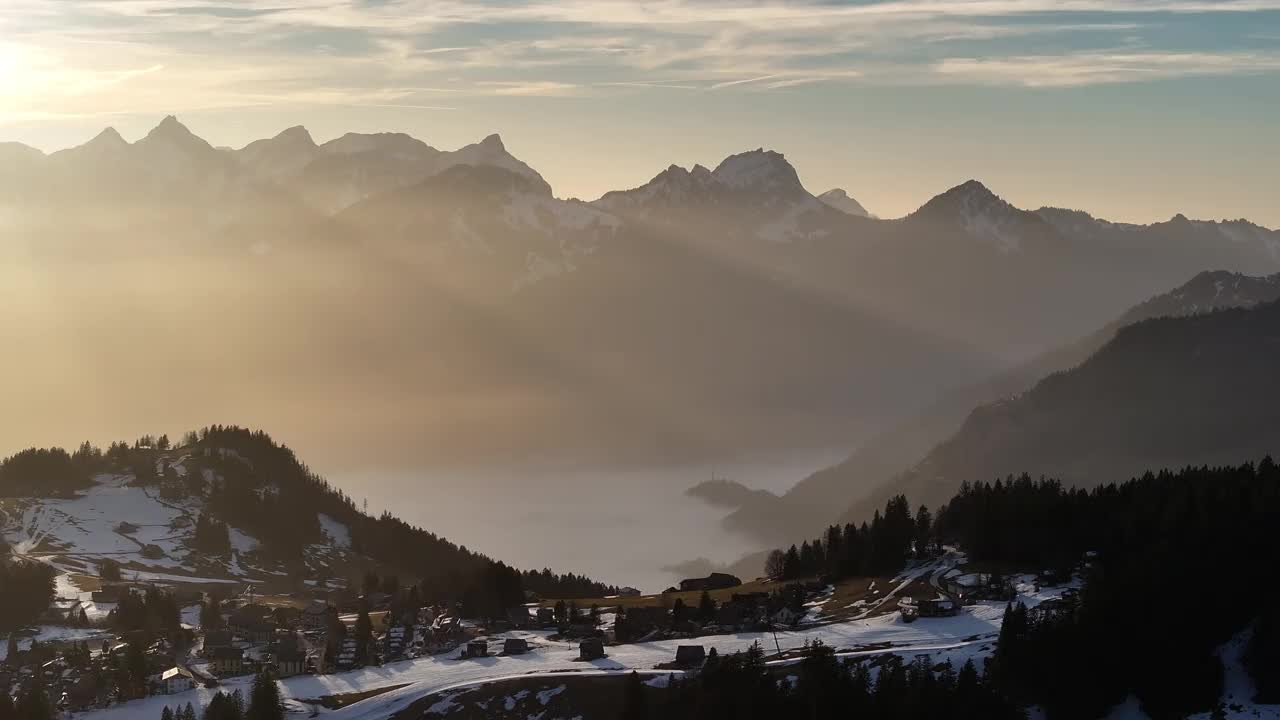 夕阳在瑞士格拉鲁斯白雪皑皑的瓦伦泽上空，航拍全景视频素材